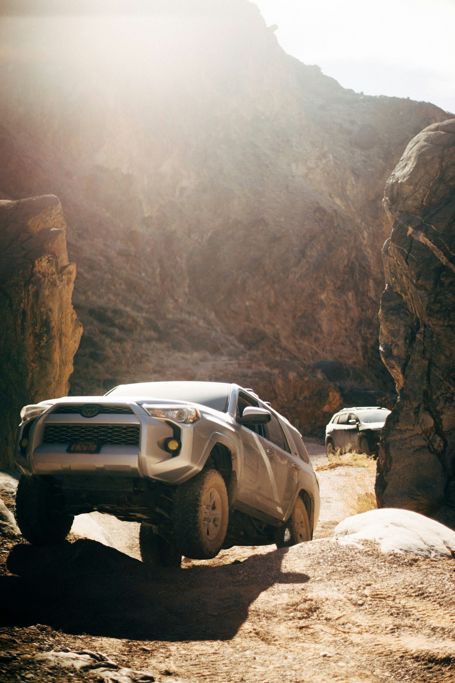Grey fifth-generation 4Runner crawling through a narrow rocky desert trench