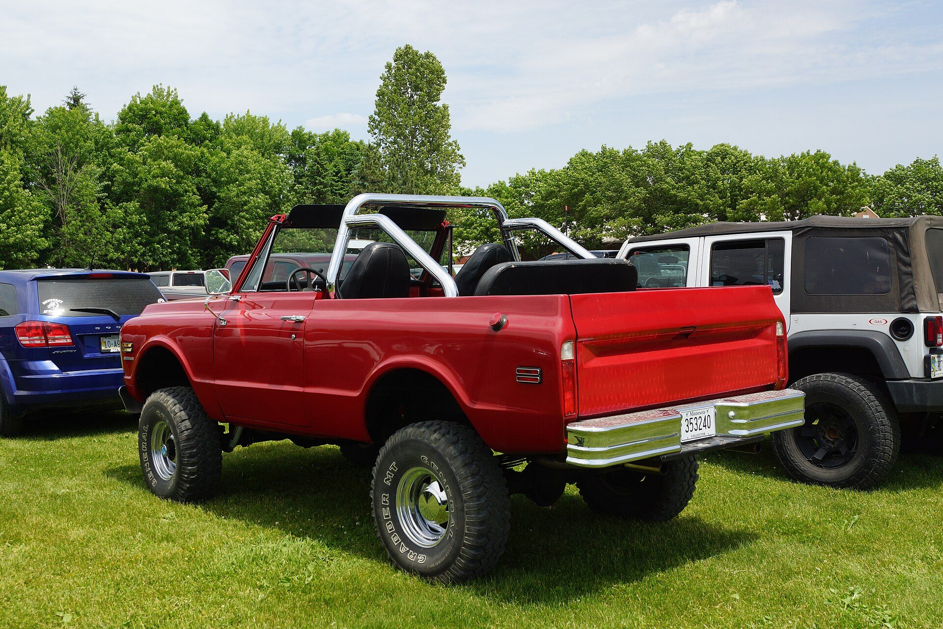 Rear three-quarter view of a red 1970 Chevrolet K5 Blazer with no top and a roll bar, showing the open rear body