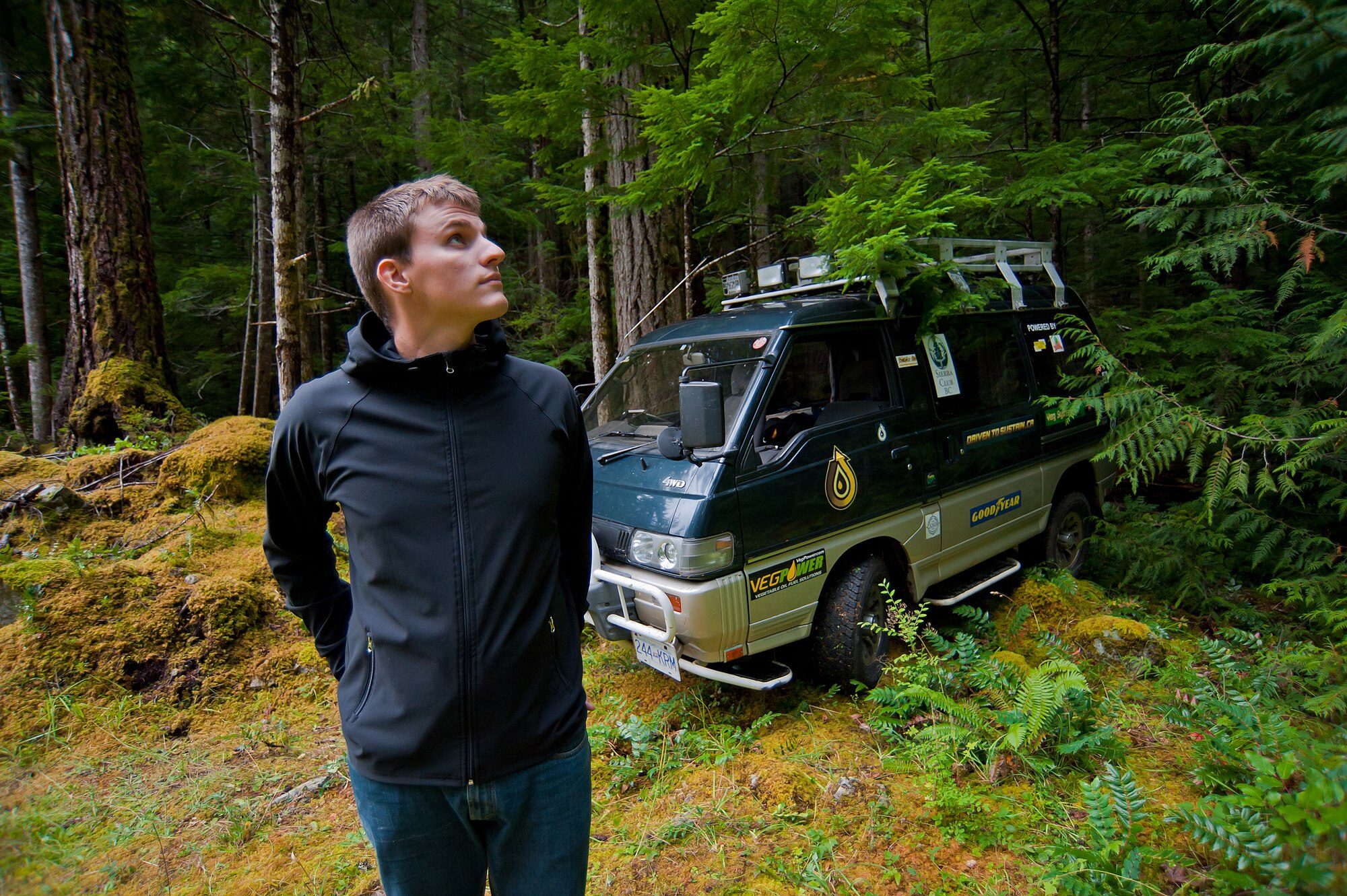 Tyson Jerry standing in a mossy old-growth forest on Vancouver Island beside his record-setting Delica Star Wagon