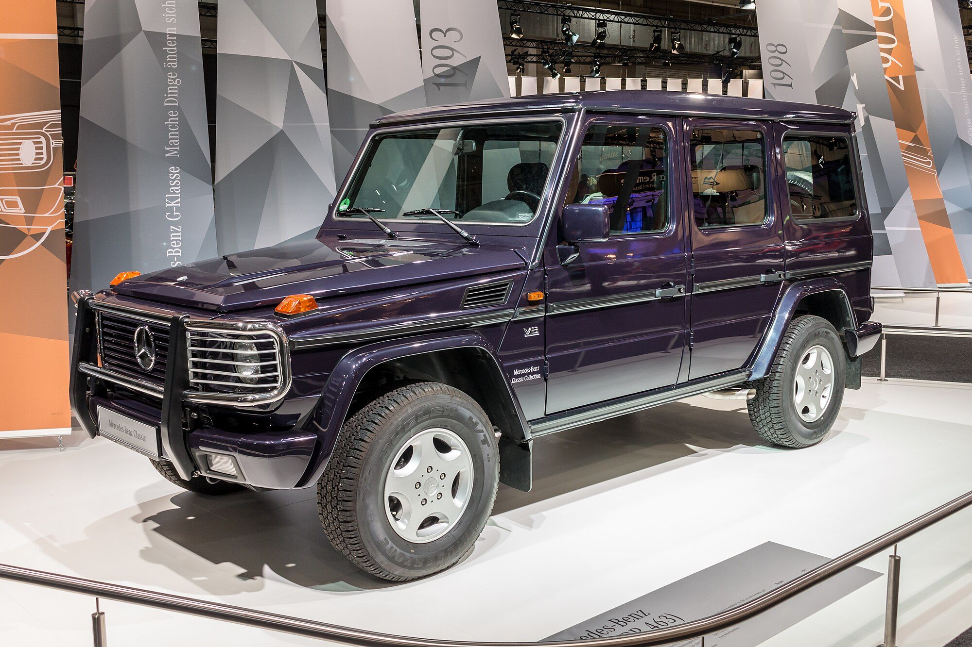 A dark purple 1993 500 GE long-wheelbase with chrome bull bar on a display stand
