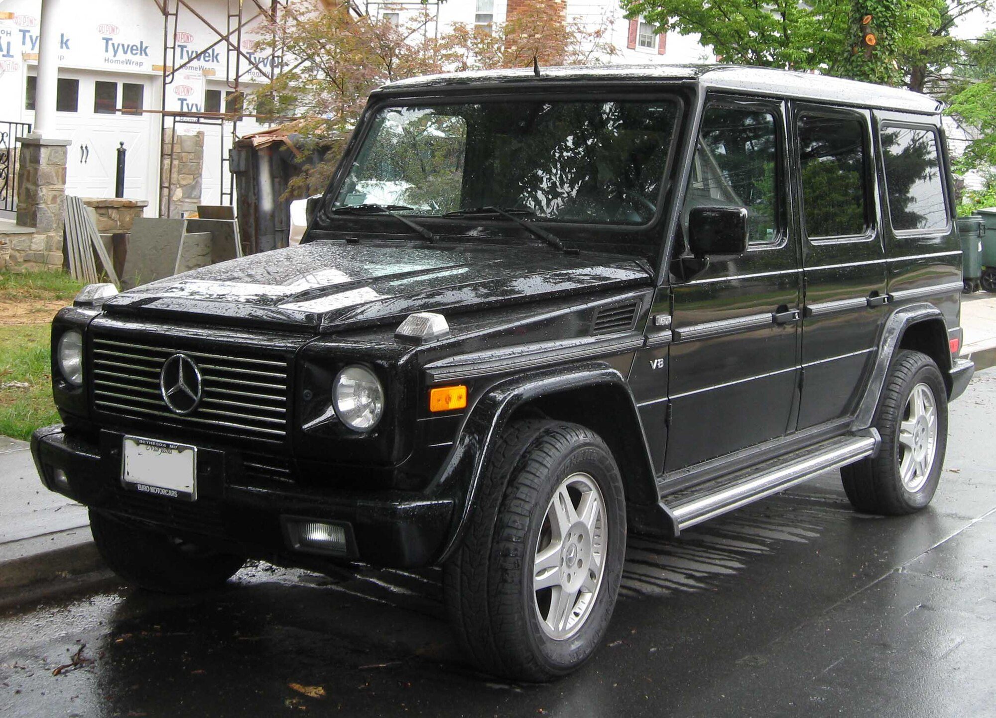 A black US-market W463 G 500 parked on a wet street in Maryland