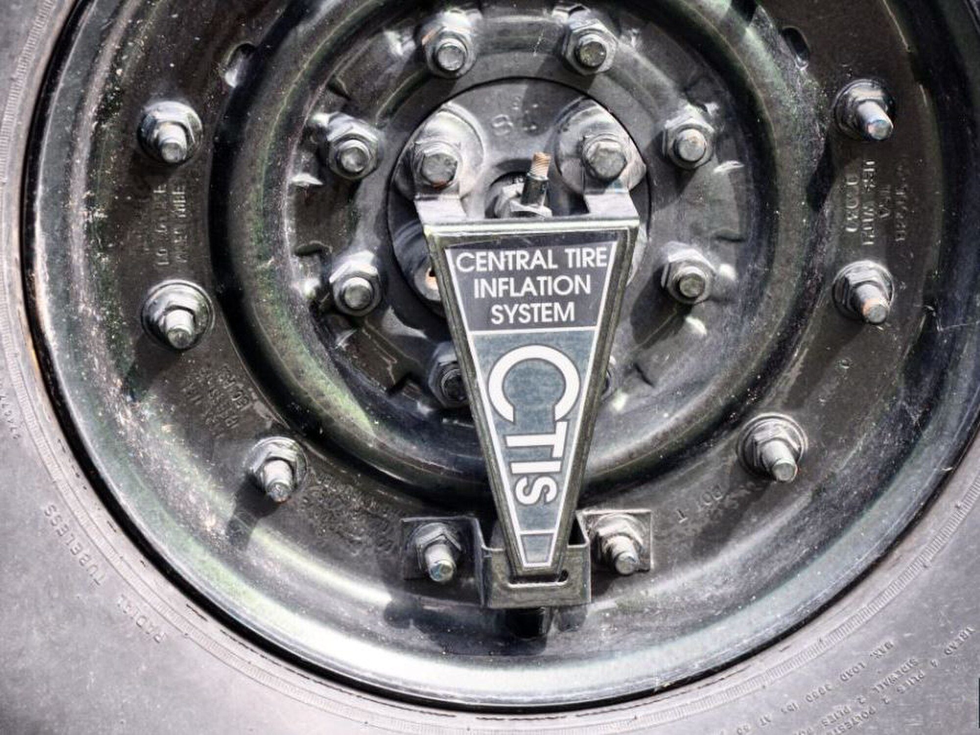 Close-up of a Hummer H1 wheel hub with the central tire inflation system air fitting and CTIS badge