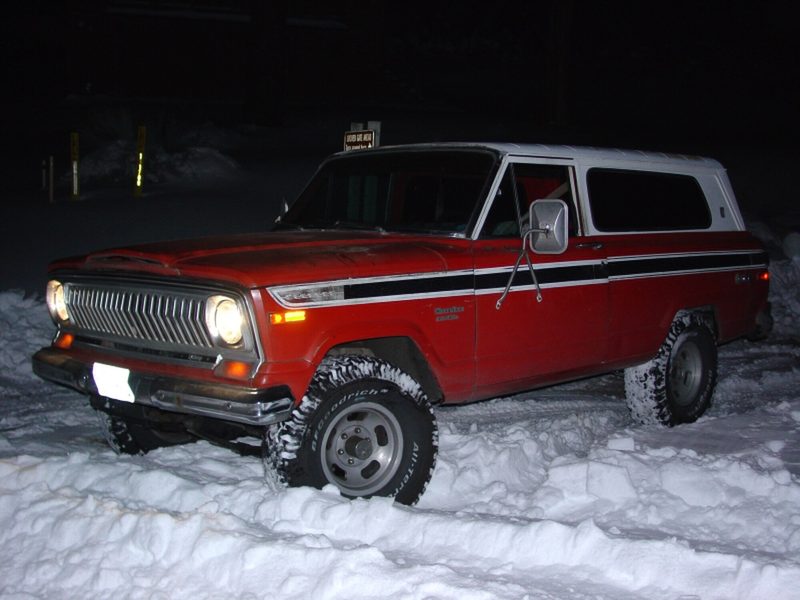 The red and white two-door Cherokee S parked in deep snow at night