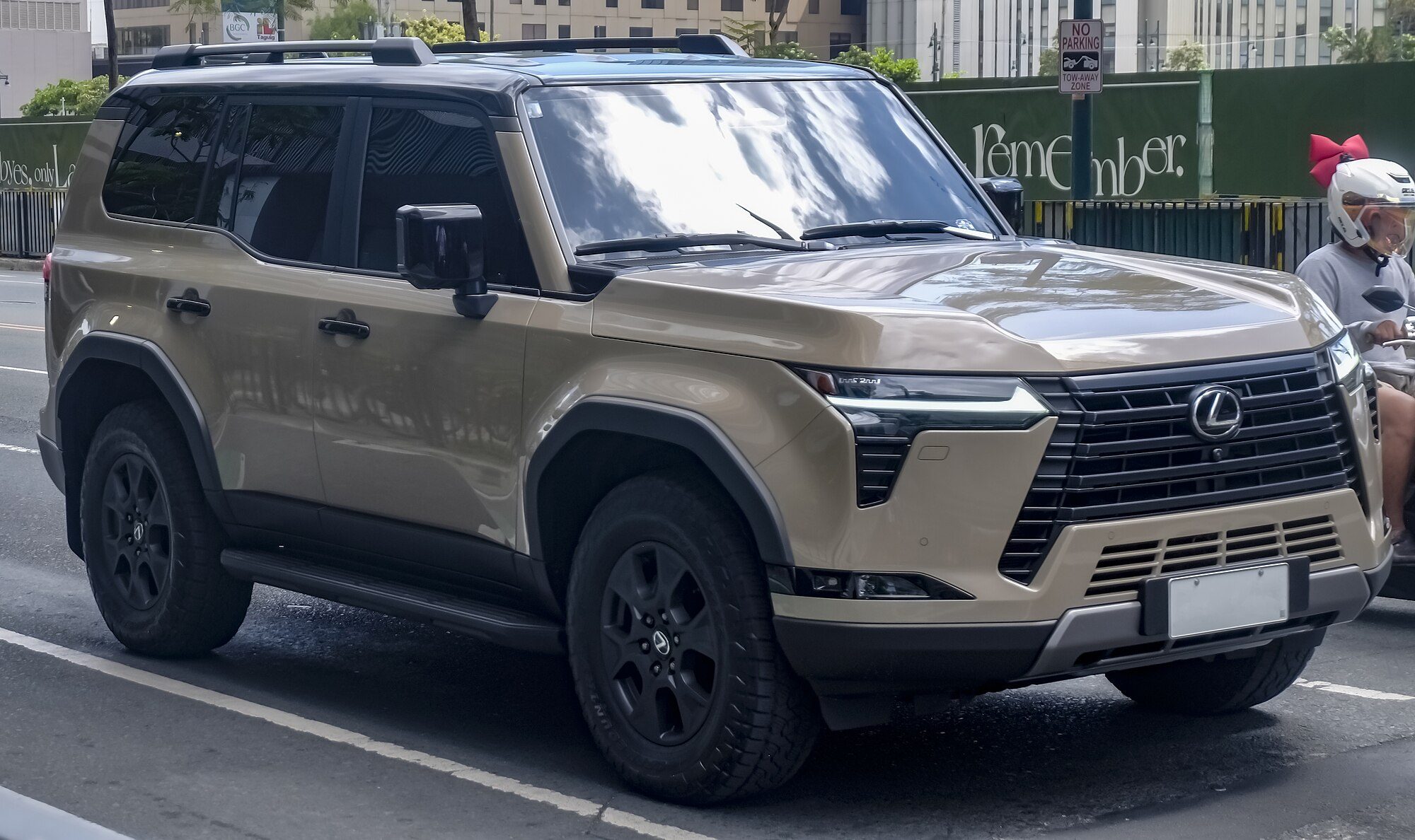 A Tactical Beige Lexus GX 550 Overtrail with black roof and all-terrain tyres on a city street