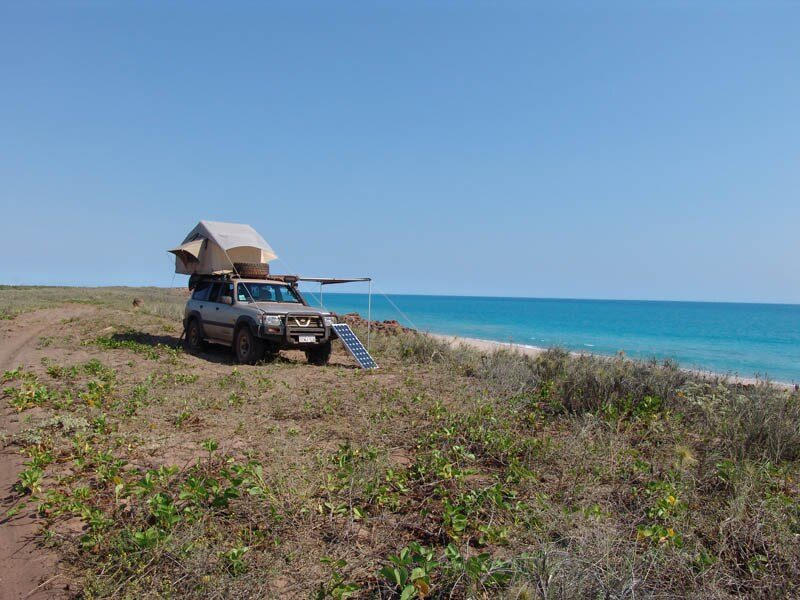 A 2001 Nissan Patrol GU with a roof-top tent camped on the coast at Barred Creek near Broome