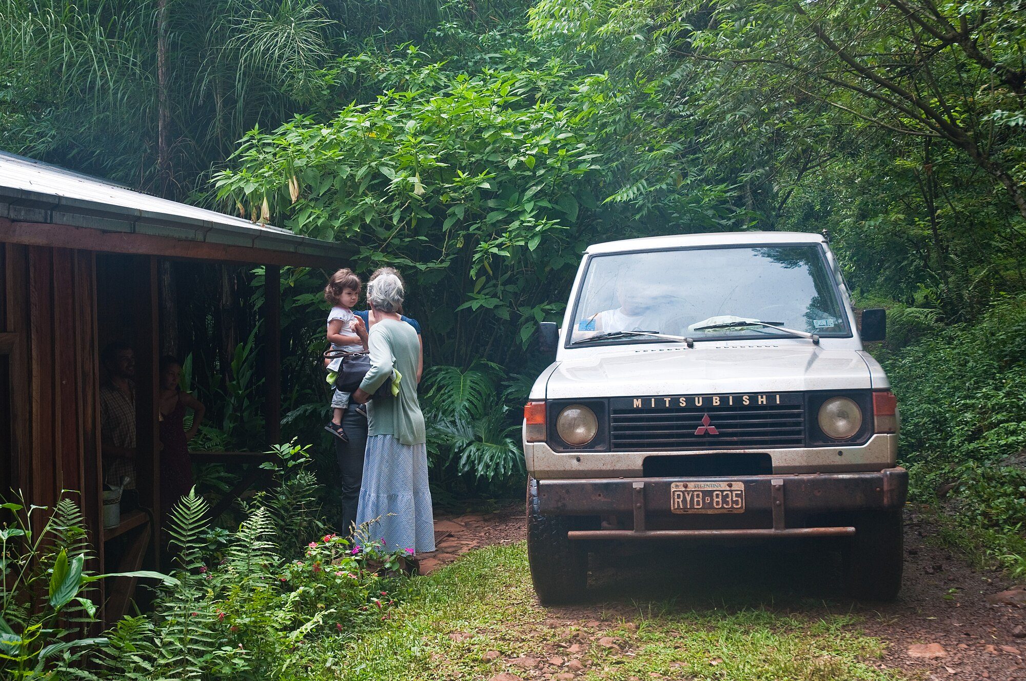 A silver first-generation Pajero on a red-dirt track beside a jungle lodge in Misiones, Argentina