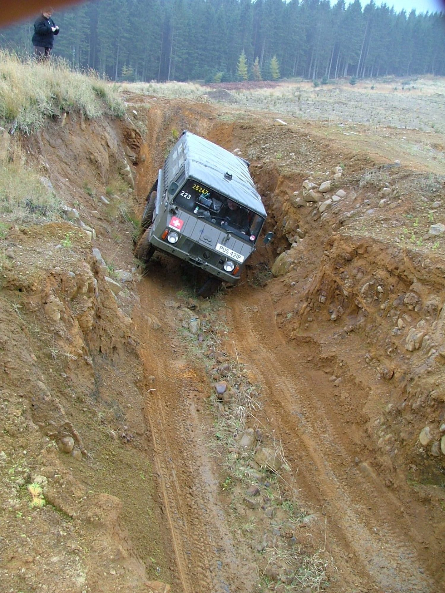 An ex-Swiss Army Pinzgauer 710 descending a deep, rutted clay gully at an off-road day in Kielder Forest